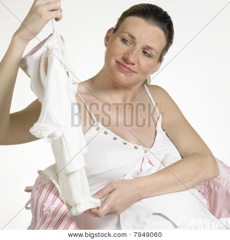 donna incinta con i vestiti per bambini