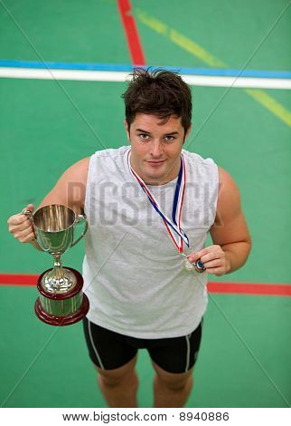 Felice giovane uomo tiene un Trophee e una medaglia