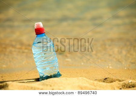 Bevarage. Bottle Of Water Drink On A Sandy Beach.