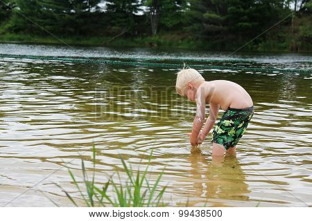 Young Child Playing Outside In Lake