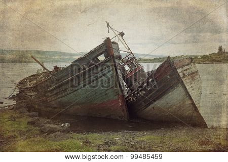 Two old wooden boats aground on isle of Mull, Scotland.  Cross processed to look like an instant picture with texture.