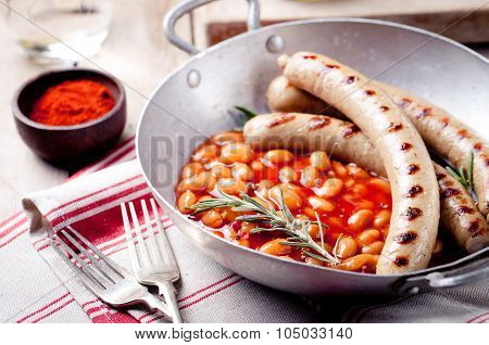 Grilled sausages with beans in tomato sauce