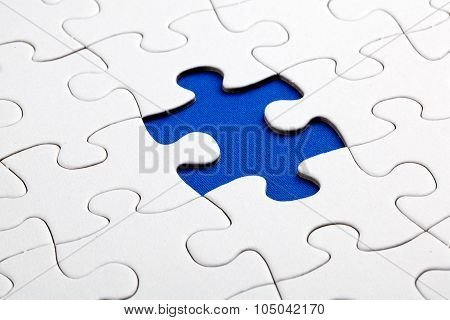 Plain white jigsaw puzzle on Blue background autism awerness symbol