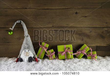 Rustic country style wooden christmas background with gift boxes in red and green colors with a santa.