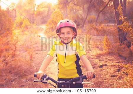 kid girl biker in mountain bike MTB at mediterranean forest