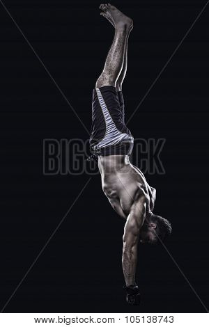 Sportsman performs a one hand stand isolated