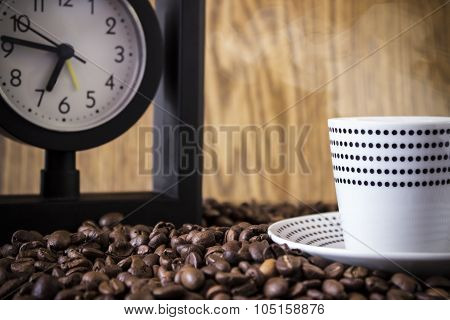 Cup Polka Dots And Clock Standing On Coffee Beans. Blur, Focus On Coffee Beans