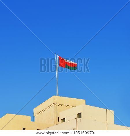 National flag of Oman is hoisted on the building in the city of Muscat.