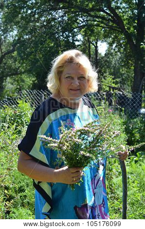 Smiling woman with flowers in garden