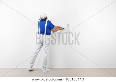 Painter With Paintroller On White Wall