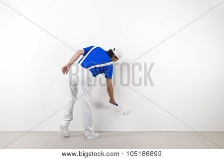 Painter With Paintroller On White Wall