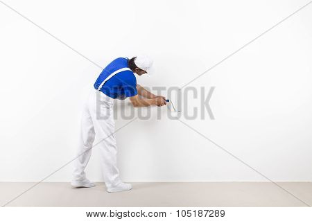 Painter With Paintroller On White Wall