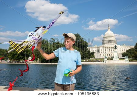 USA, WASHINGTON - AUG 26, 2014: Boy (with model release) and a kite is playing near United States Capitol at summer sunny day.