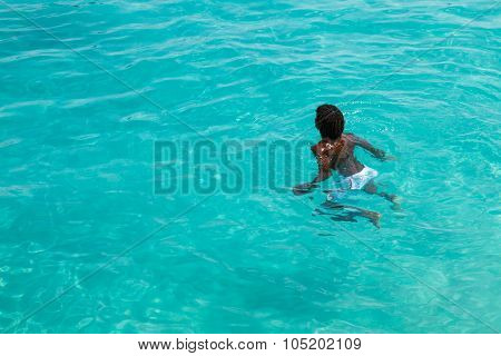 Teenage Cape Verdean Boy Swimming On The Turquoise  Water Of Santa Maria Beach In Sal Cape Verde - C