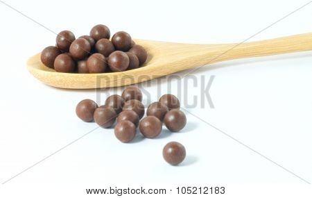 Wooden Spoon Full Of Herbal Cough Lozenges On A White Background