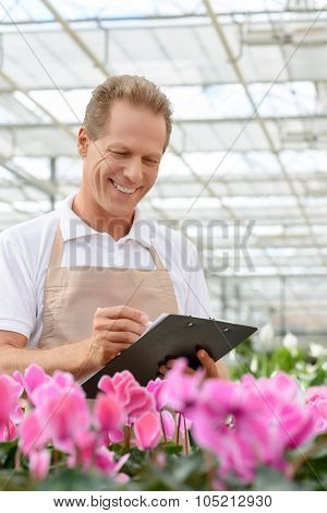 Professional florist workin gin the greenhouse