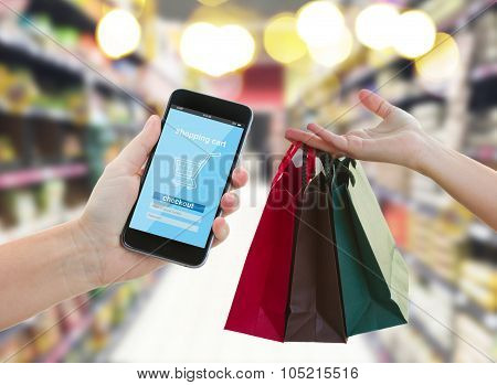 hand holding a modern smartphone in supermarket