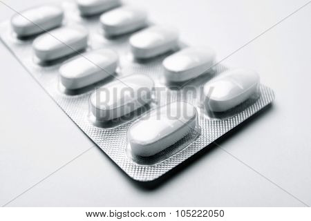 Forefront of a white medicine pills in blister pack.