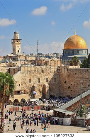 JERUSALEM, ISRAEL - SEPTEMBER 20, 2013: Sunny morning in the holiday of Sukkot. Morning prayer at the Western Wall of the Temple. Religious Jews in white prayer shawls
