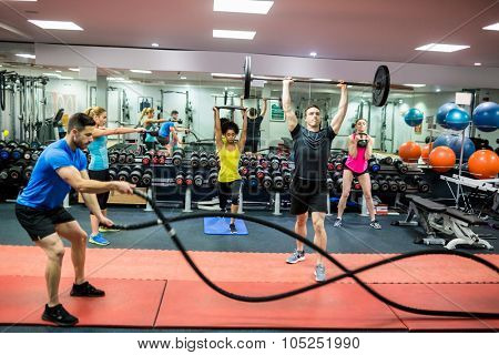 Fit people working out in weights room at the gym