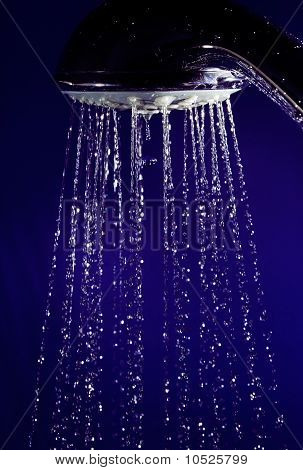 Mano doccia doccia con movimento fermato acqua scende sul profondo blu