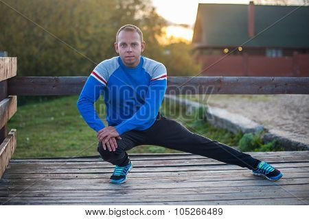 Sport Man Stretching Aoutdoors Doing Exercises Evening At Sunset. Fitness Concepts