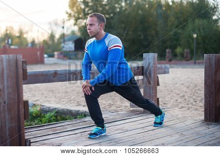 Sport Man Stretching Aoutdoors Doing Exercises Evening At Sunset. Fitness Concepts