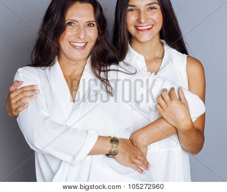 cute pretty teen daughter with mature mother hugging, fashion style brunette makeup