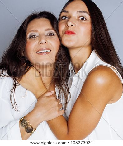 cute pretty teen daughter with mature mother hugging, fashion style brunette makeup