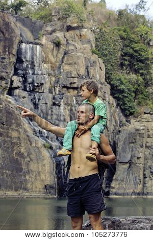 father and son making a trip to waterfall together, happy family on vacations, nature place pongour