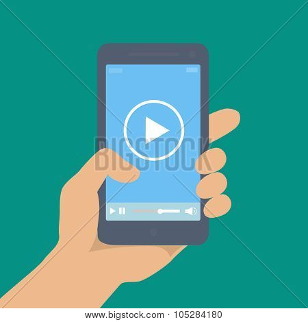 Mobile phone with video player on the screen in a human hand