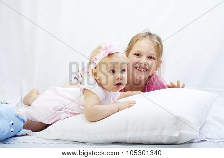 cute little sister play with  newborn on a white background