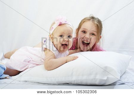 cute little sister play with  newborn on a white background