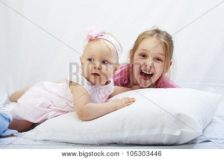 cute little sister play with  newborn on a white background