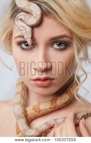 Beautiful girl and a python, which wraps around her body