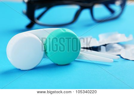 Contact Lenses In Container With Solution On Blue Background