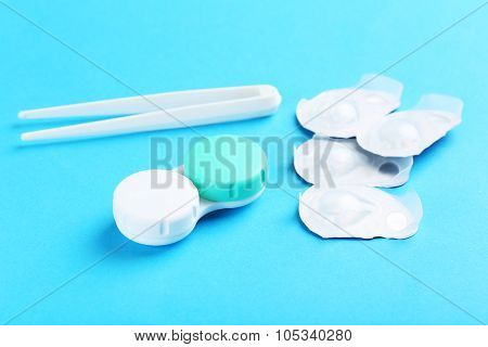 Contact Lenses In Container With Solution On Blue Background
