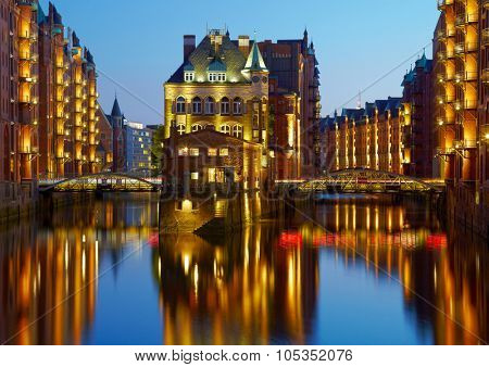 Old Speicherstadt in Hamburg illuminated at night. Sunset background
