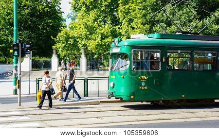 POZNAN POLAND - AUGUST 25 2013: People passing the street with waiting green tram in the city center