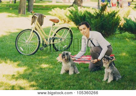 Young Woman With Dogs And Bicycle Having Picnic In The Park