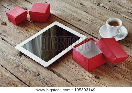 White Tablet With Open Gifts And A Cup Of Coffee