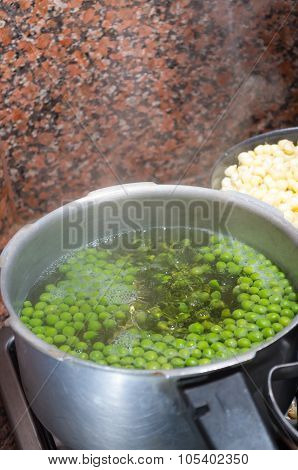 Green peas cooking in silver colored metal pot. fanesca preparation concept