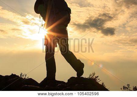 silhouette of backpacker on sunset mountain peak