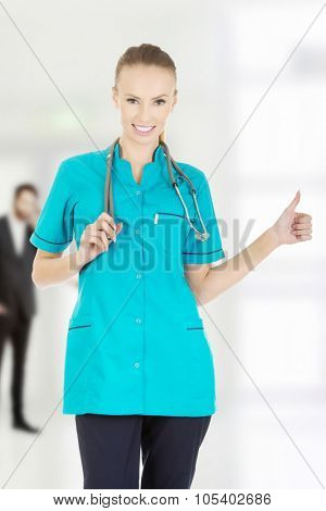 Beautiful smiling woman doctor with thumbs up.
