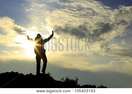 silhouette of backpacker on sunset mountain peak