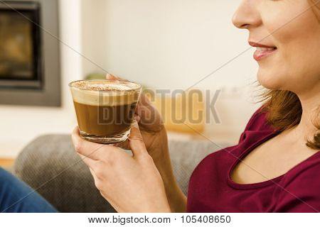Beautiful woman at home drinking a capuchino