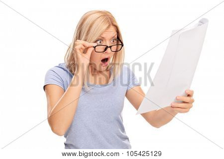 Studio shot of a shocked woman looking at the bills in disbelief isolated on white background