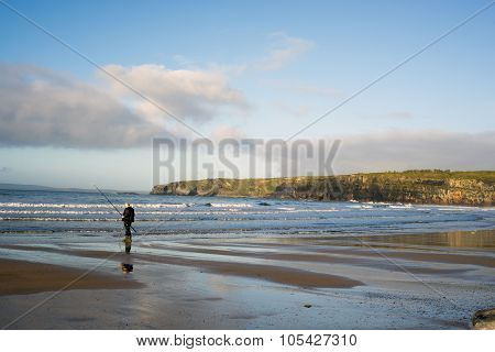 Lone Fisherman Fishing Near The Cliffs