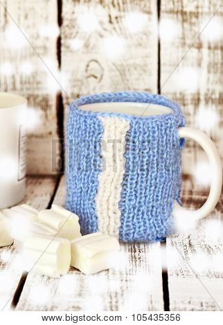 Mug with milk and marsmallow on the white table
