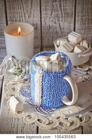 Mug with milk and marsmallow on the white table